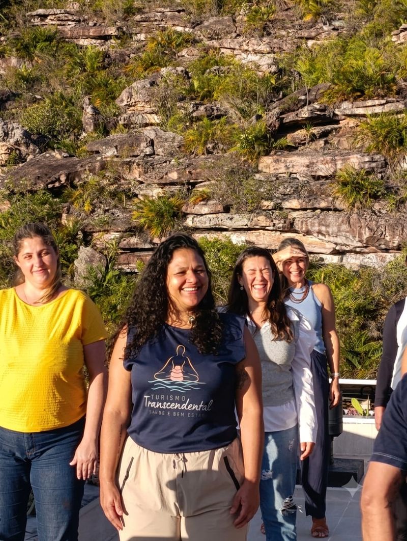 Participantes sorrindo ao ar livre, com os morros da Chapada ao fundo